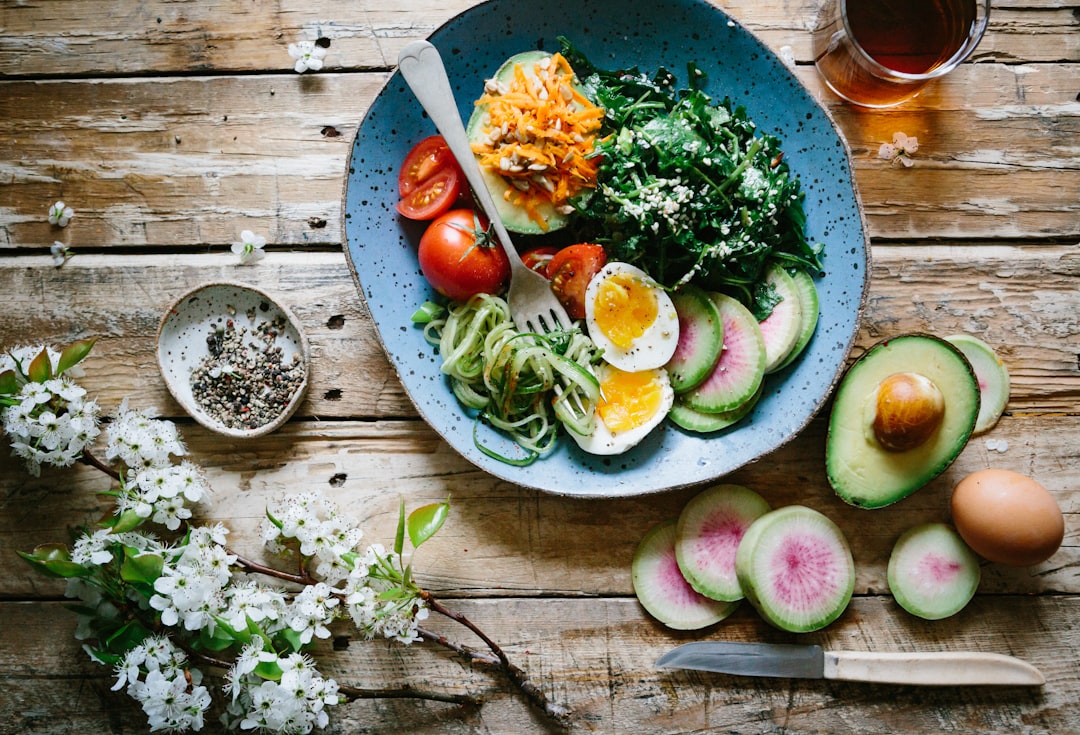 Assortment of healthy fats and vegetables including avocado, nuts and leafy greens representing brain nutrition